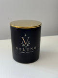Veluno Obsidian — matte black jar candle with a gold lid and the Veluno monogram