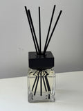 Veluno reed diffuser — clear square glass bottle with a black wooden cap and black reeds